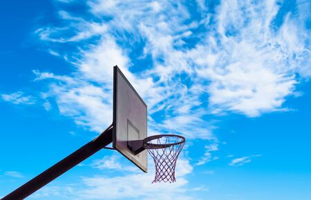Isolated basketball hoop under cloudy sky