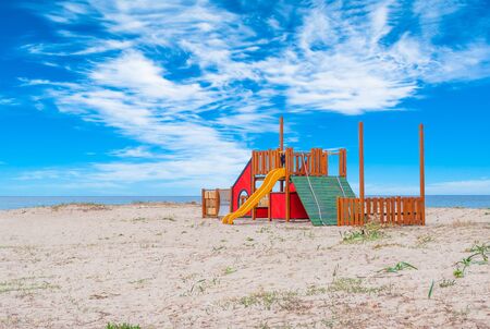 Small wooden playground for children on the beach in a sunny dayの写真素材