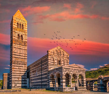 View at the Basilica Holy Trinity of Saccargia - Sardinia - Italy at sunset with dramatic sky and red cloudsの写真素材