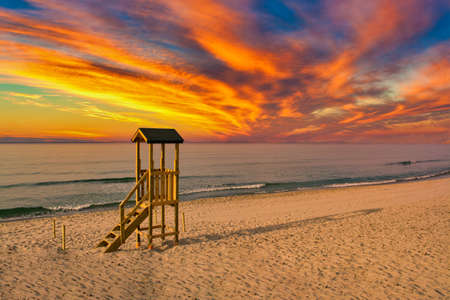 lifeguard tower on the beach with a dramatic red sunsetの写真素材