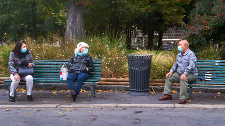 MILAN-ITALY - 11 october 2020: Aged people chatting on a benches near Castello Sforzesco in Milan...