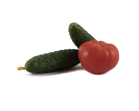 Fresh gherkins and big red tomato isolated on white backgroundの写真素材