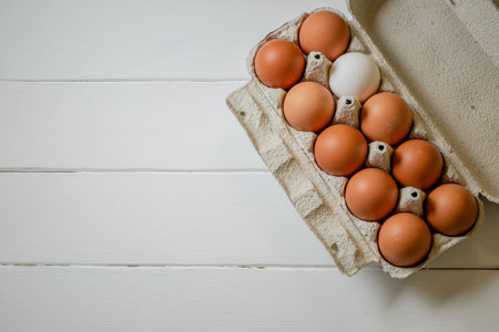 Fresh chicken eggs in a paper tray on the table, selective focus