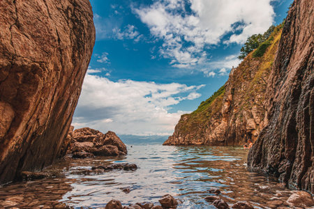 A small stone beach by the sea, framed by the rock