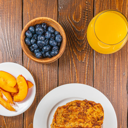 French toast on a plate with blueberries, orange juice, nectarine for breakfastの写真素材