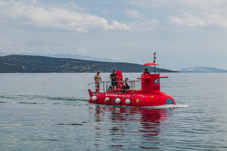 Krk Croatia 26.06.24 A red tourist submarine swims up to the shore of the portのeditorial素材