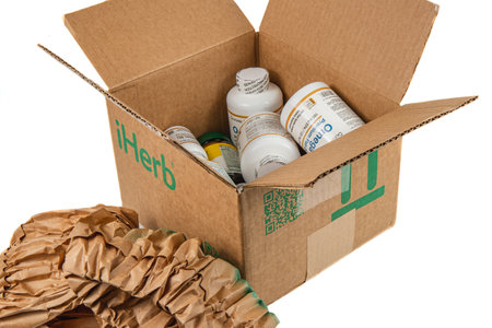 Lviv Ukraine 08.17.24 open iHerb box with vitamins on a white backgroundのeditorial素材