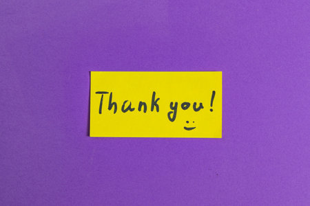 Small yellow note with the word thank you on a purple backgroundの写真素材