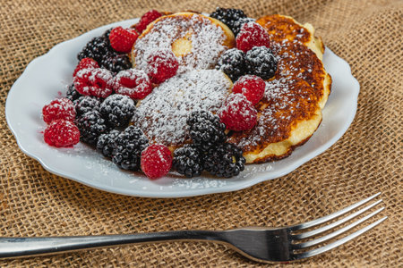 Cottage cheese pancakes with fresh raspberries, blackberries and powdered sugar