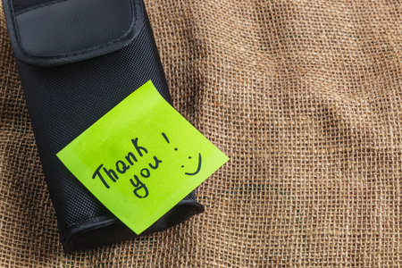 Black box on knitted background with green thank you labelの写真素材