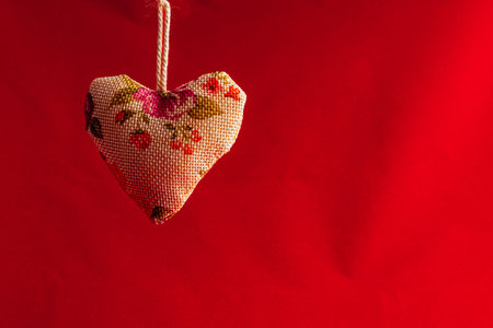 Textile heart with flowers on a red backgroundの写真素材