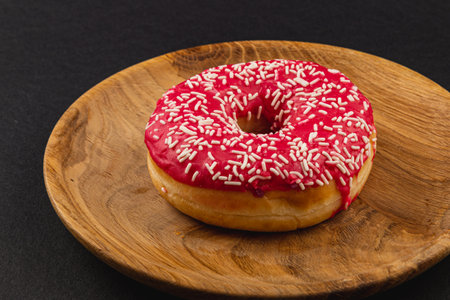 fresh delicious donut with red glaze on a wooden plate,  High quality photo.の写真素材