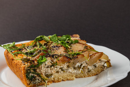 A delicious homemade pizza featuring a unique blend of creamy cottage cheese, sweet pear slices, and fresh arugula, served on a white plate. This flavorful dish is perfect for any time.の写真素材