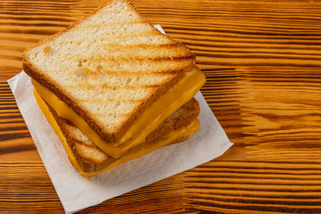 A warm grilled cheese sandwich features golden, toasted bread and melted cheese, perfect for any meal or snack. Enjoy this savory treat during breakfast, brunch, or lunch.の写真素材