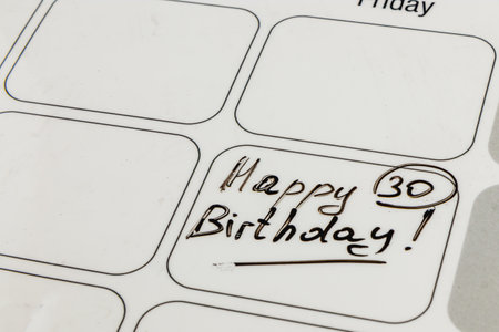 A planner shows a handwritten note celebrating a milestone birthday. The date features Happy 30 Birthday! highlighting a significant life event to be celebrated.の写真素材