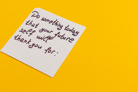A handwritten note on a bright yellow background encourages taking action today for a better future. It emphasizes the importance of planning ahead and self-care.の写真素材