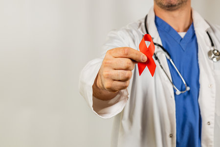 A healthcare professional in a white lab coat displays a red ribbon symbolizing support for health...