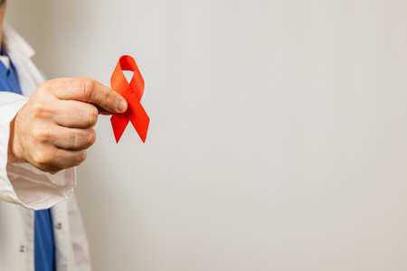 A healthcare professional in a lab coat displays a red ribbon, emphasizing the importance of...