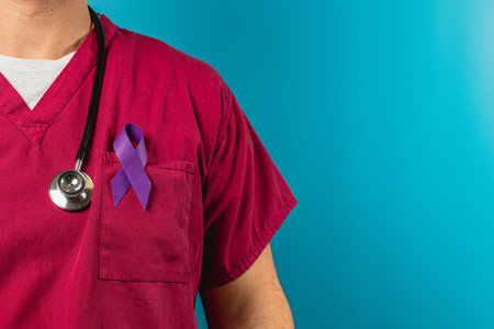 A healthcare worker in scrubs displays a purple ribbon on their uniform, symbolizing support for an important awareness campaign. The bright blue background emphasizes the message.の写真素材