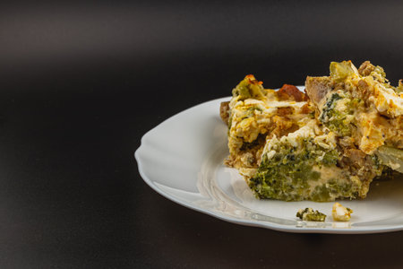 A mouthwatering casserole features layers of egg, broccoli, chicken fillet, and sour cream, garnished with garlic for a savory flavor. Perfect for family dinners or gatherings.の写真素材