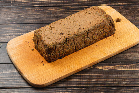 A block of homemade chicken liver pate rests on a wooden cutting board, showcasing a rustic and hearty appearance. Perfect for spreading on crackers or bread.の写真素材