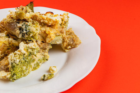 This hearty casserole features layers of tender chicken fillet, fresh broccoli, and creamy egg mixture, all seasoned with garlic and topped with sour cream, perfect for a comforting meal.の写真素材
