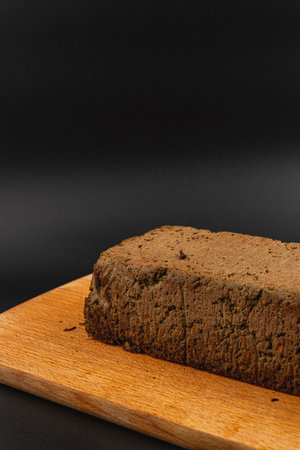 A block of homemade chicken liver pate rests on a wooden cutting board. The rich and smooth texture invites tasting, showcasing culinary skill and gourmet flavors.の写真素材