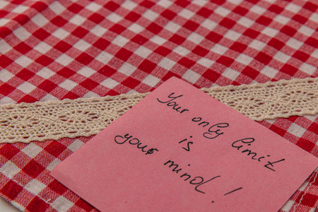 A motivational note is placed on a red and white checkered fabric with lace trimming. It conveys a positive message about personal limits, encouraging a growth mindset.の写真素材