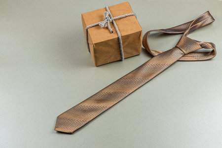 A beautifully crafted tie rests alongside a neatly wrapped gift box, showcasing an ideal gift for father's day or a birthday celebration. This arrangement captures the essence of honoring fathers.の写真素材
