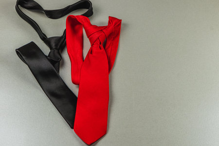Two ties, one red and one black, are artistically arranged on a smooth surface. These gifts symbolize love and appreciation for fathers during birthday or Father's Day celebrations.の写真素材