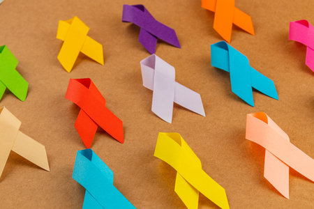 A collection of awareness ribbons in different colors laid out on a flat surface, representing various health issues and campaigns. Each ribbon stands for support in the fight against diseases.の写真素材