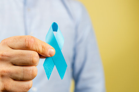 A person holds a blue ribbon, symbolizing cancer awareness. This display is part of a broader campaign focusing on health, support, and prevention efforts in healthcare.の写真素材