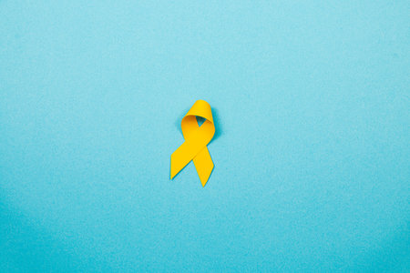 A yellow ribbon symbolizes hope and solidarity in the fight against cancer. It represents awareness for cancer prevention and support for those affected by the disease.の写真素材