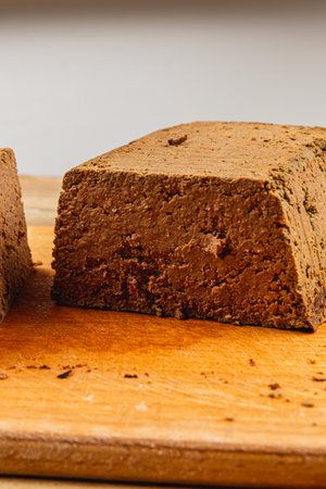 Homemade chicken liver pate sits on a wooden cutting board, showcasing its smooth texture and rich...