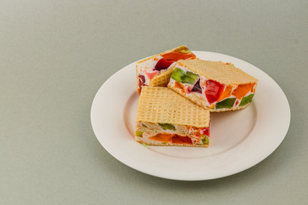 Jelly waffle cakes are layered with cream, yogurt, and fresh fruits like kiwi, strawberries, and raspberries. Perfect for a sweet treat at any time.の写真素材