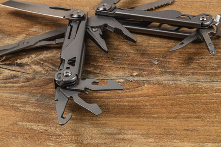 Lviv Ukraine 04.02.25 Two versatile multitools laid on a rustic wooden surface, showcasing various functions such as cutting, screwing, and gripping, ideal for outdoor and handyman tasks.の写真素材