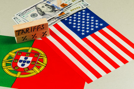 Tariffs are placed on a table alongside the flags of Portugal and the USA, with a stack of currency notes, highlighting trade discussions and political factors.の写真素材