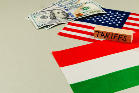 Currency notes and flags symbolize trade discussions, highlighting issues of tariffs and manipulation in political contexts related to USA and Hungary.の写真素材