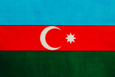A large flag showcasing the colors of Azerbaijan. The flag features a blue top, red middle with a...