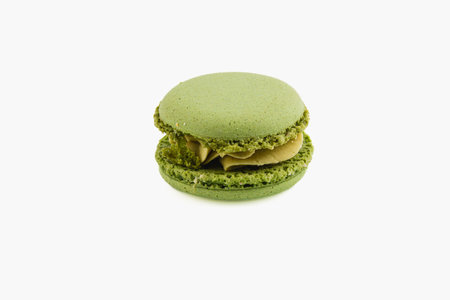 This vibrant green macaron features a smooth and creamy filling. The delicate shell is light and airy, making it an appealing dessert choice.の写真素材
