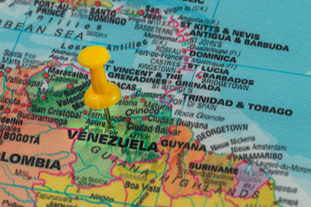 A vibrant map displays Venezuela, marked by a bright yellow pin, showcasing its location in South America next to Colombia and Guyana, surrounded by Caribbean waters.の写真素材