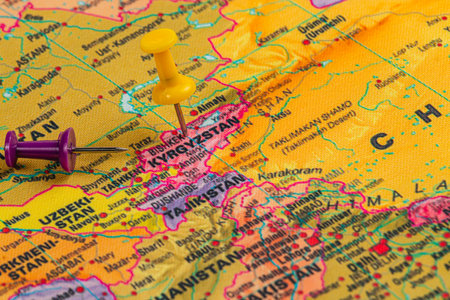 A topographical map displays Kyrgyzstan and neighboring countries, featuring a yellow and purple...