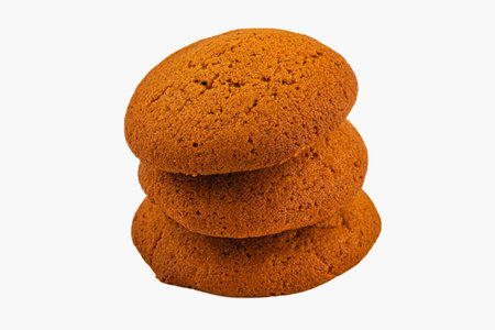 Three soft ginger cookies are neatly stacked, showcasing their warm brown color and slightly crispy...