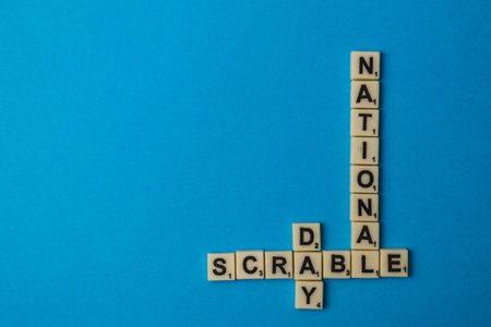Lviv Ukraine 02.26.26 Letter tiles spell out National Scrabble Day on a blue background. Scrabble...