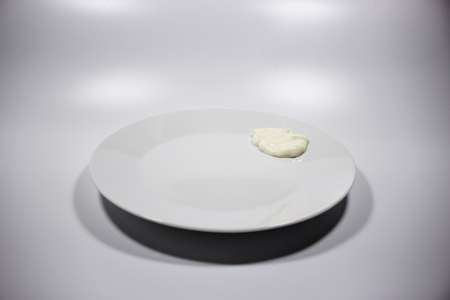 White plate with cream sauce, isolated