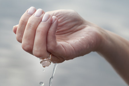 Woman's hand with water and jewelryの写真素材