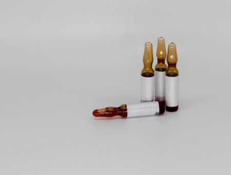 Vaccine in a glass ampoule, on a white background with a place under the textの写真素材