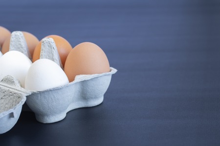 chicken eggs in a cardboard tray on backgroundの写真素材