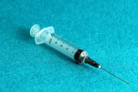 medical syringe with medicine on a blue background