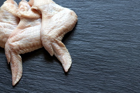 fresh raw chicken wings on a black background cooking healthy food meal
